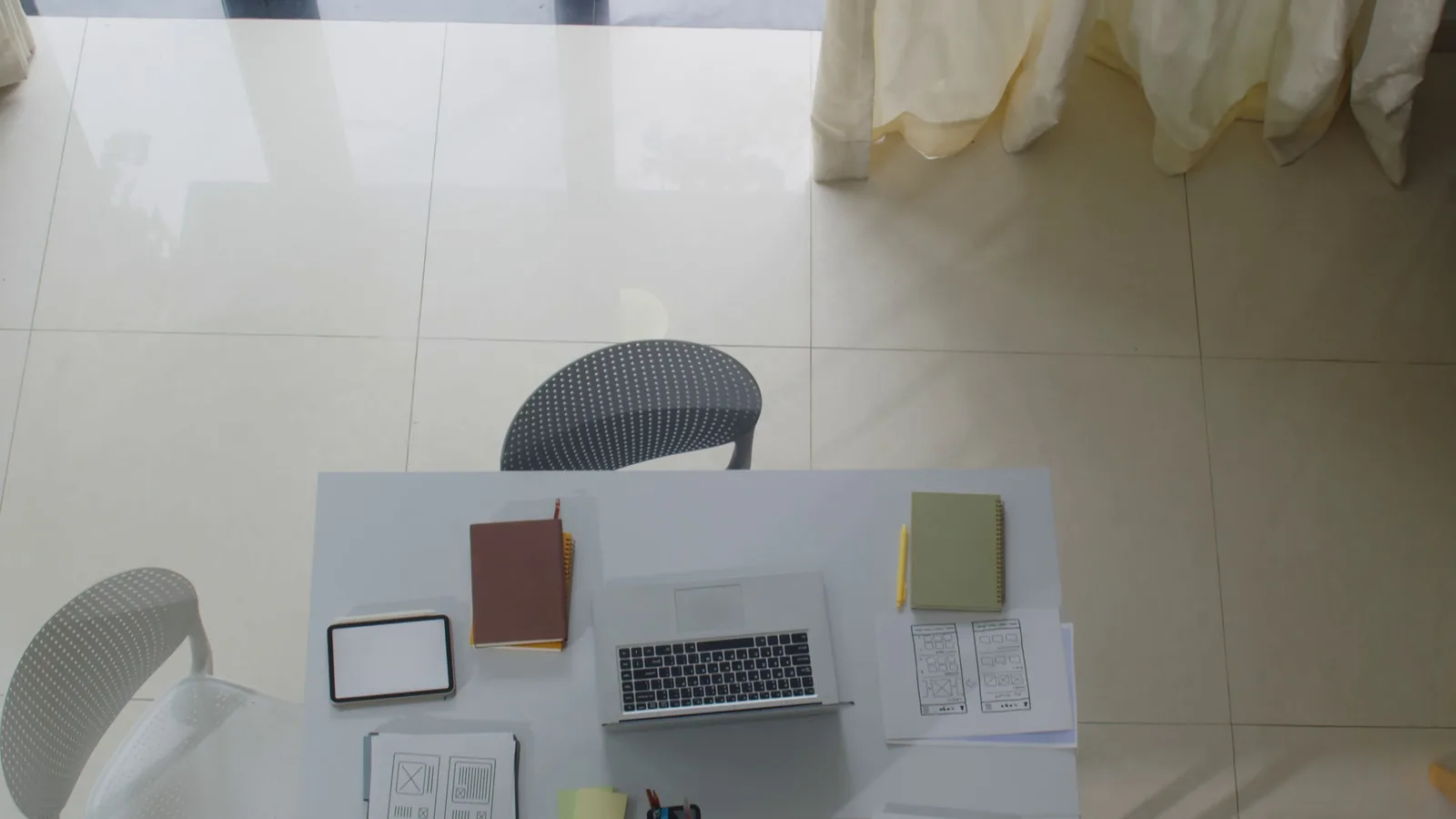 Directly above view of laptops, tablet computer and documents on working table of IT specialists office